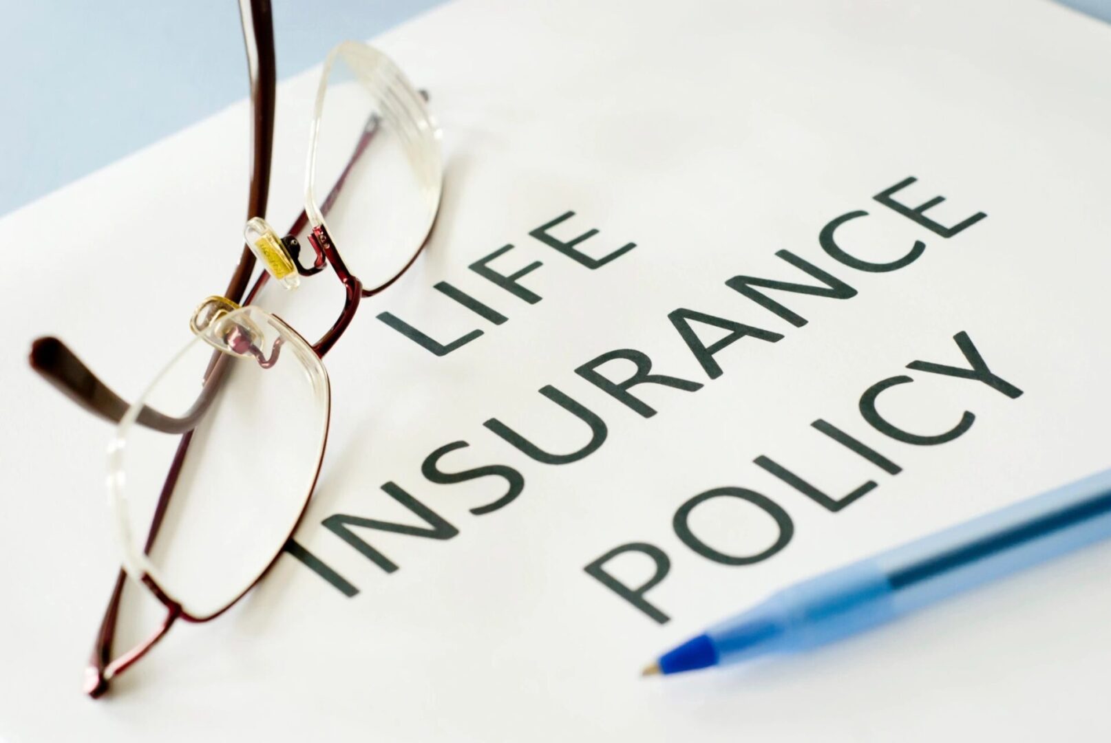 A life insurance policy is written on top of the paper.